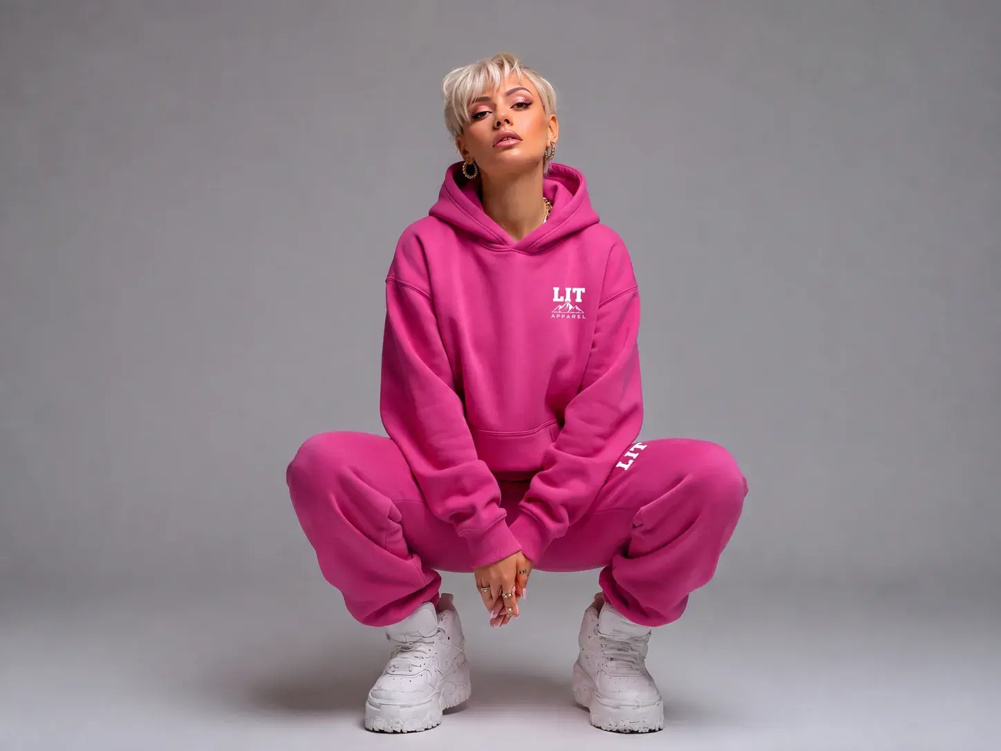 A woman in the fuchsia LIT Sweat Suit in a bright studio.