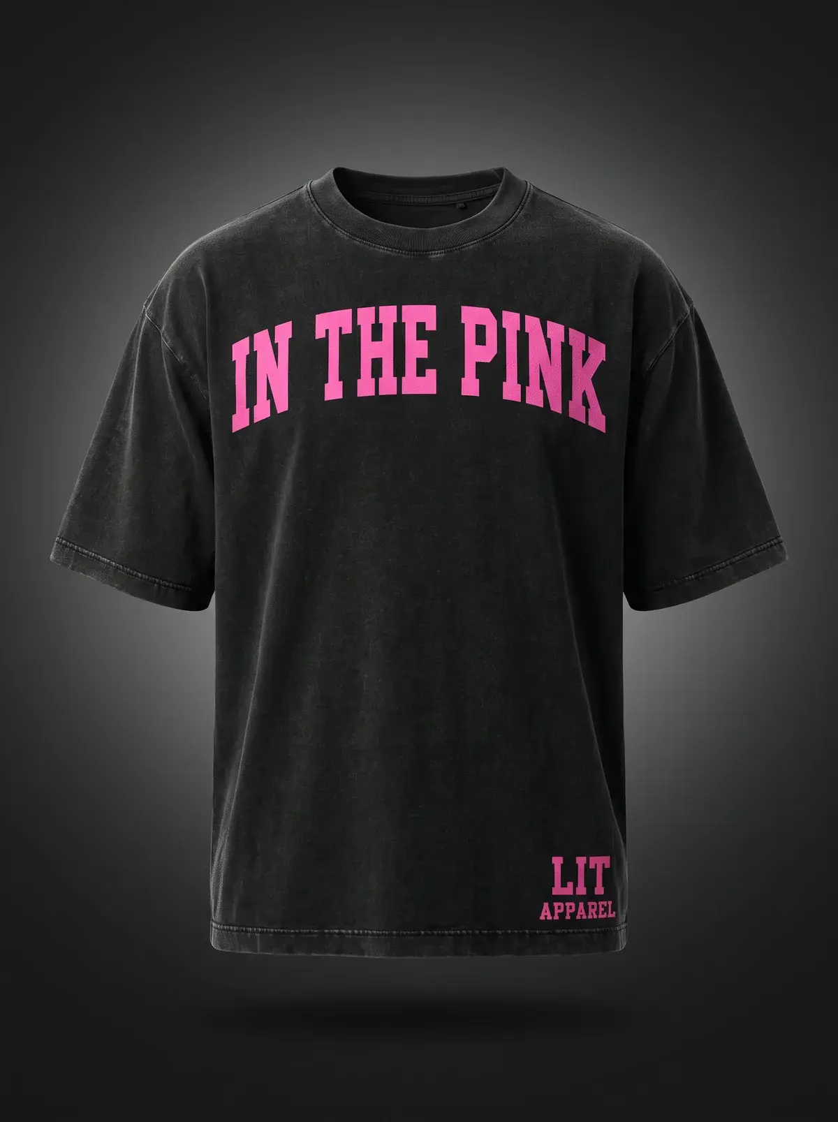 In The Pink Tee in Washed Black, photographed front-on against a paper ground.